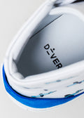 Primer plano de una zapatilla de deporte de caña alta blanca y azul con el nombre de la marca "I Just Like Birds" en la plantilla, con especial atención a los detalles de costura y textura.