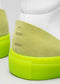 Gros plan sur le talon arrière d'une basket montante V4 en cuir blanc et citron vert, avec une semelle vert fluo et des détails en daim vert pâle, avec le marquage "nike" en relief.