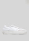 Vue latérale d'une Start with a White Canvas Vegan low top sneaker avec un laçage sur le devant et une épaisse semelle en caoutchouc blanc, présentée sur un fond gris clair.