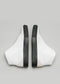 Un paio di V32 Vegan White W/Beige high top sneakers con dettagli di cerniera neri su sfondo grigio.