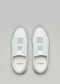 Un par de zapatillas V7 de cuero blanco con escayola sneakers sobre un fondo gris claro, vistas desde arriba.