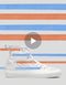 Una sneaker high-top bianca su uno sfondo a strisce rosse e blu con un'icona del pulsante di riproduzione in sovrimpressione, che suggerisce un contenuto video sulle scarpe personalizzate New Medium 4/5.